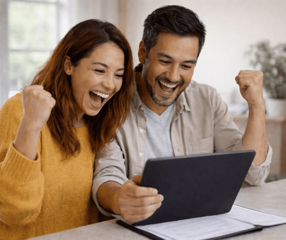 Happy homeowners reviewing their cash-out refinance approval on a laptop, celebrating access to home equity.